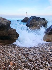 Scenic view of rocks in sea against sky