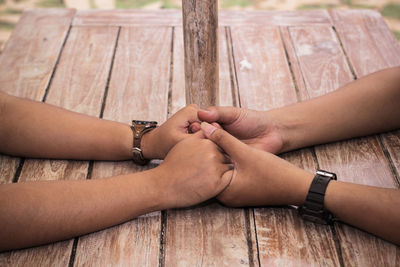 Midsection of couple holding hands