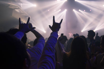 Group of people gesturing at music concert