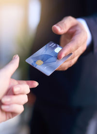 Midsection of man holding credit card