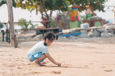 Side view of young woman exercising at beach