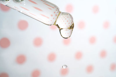 A dripping pipette with a drop of cosmetics gel.