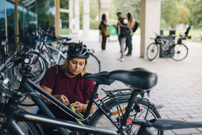 Portrait of young woman on bicycle in city