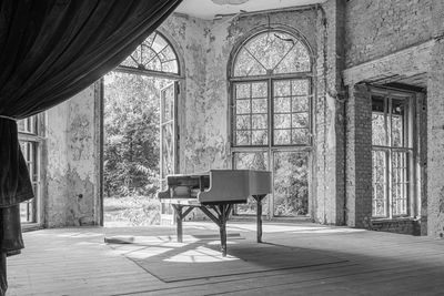 Empty chairs and table in abandoned building