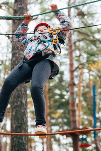 Low section of woman standing on fence