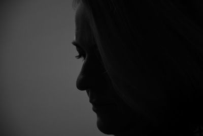 Close-up of sad woman against gray background