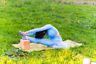 Side view of woman relaxing on field