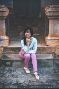 Full length of young woman sitting on steps