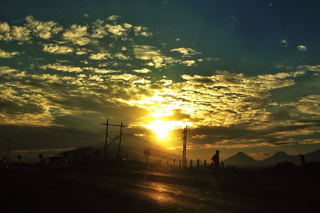 sunset, sky, silhouette, road, scenics, orange color, cloud - sky, sun, landscape, transportation, beauty in nature, tranquil scene, tranquility, dramatic sky, nature, cloud, idyllic, the way forward, car, sunlight