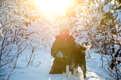 Full length of girl with daughter in snow during winter