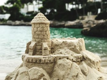 Sandcastle on shore at beach