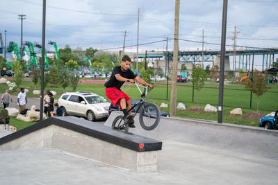 Full length of man skateboarding on motorcycle against sky