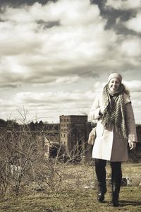 Full length of woman standing on field against sky