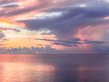 Scenic view of sea against dramatic sky during sunset