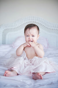 Portrait of girl crying on bed