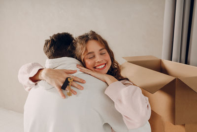 Portrait of young woman sitting on bed at home