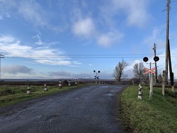Road amidst field against sky