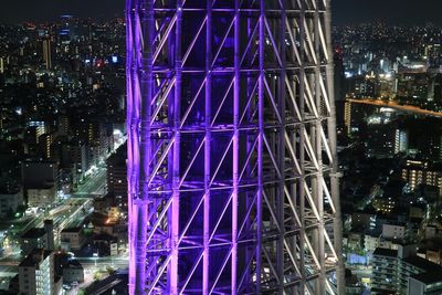 Illuminated ferris wheel in city at night