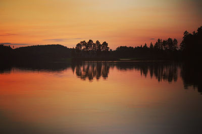 Scenic view of lake against orange sky