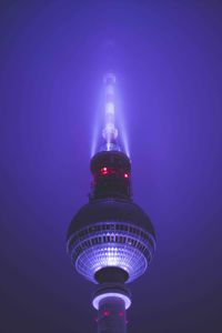 Low angle view of illuminated tower against sky at night