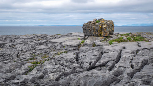 Rock formation on beach against sky