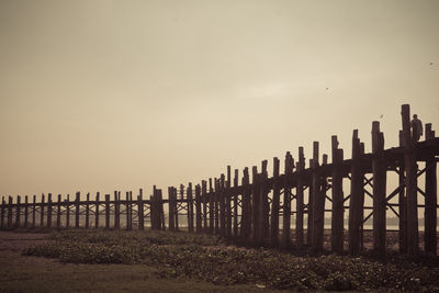 Wooden gate on beach against sky