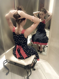 Young woman standing against wall