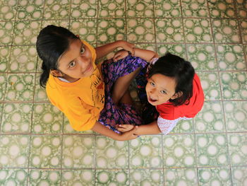 High angle portrait of girls sitting on floor