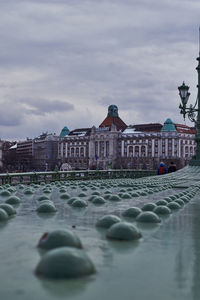 View of buildings in city against cloudy sky