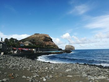 View of calm beach against blue sky