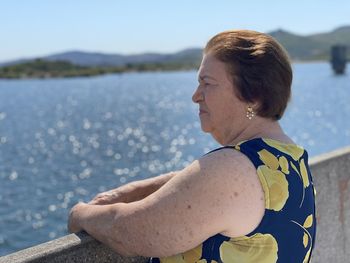 Woman sitting by sea