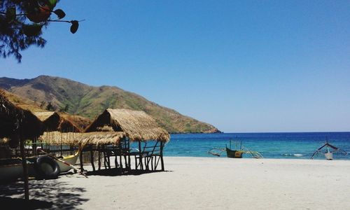 Scenic view of beach against clear blue sky