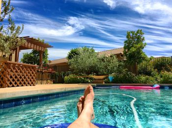 Low section of man relaxing in swimming pool