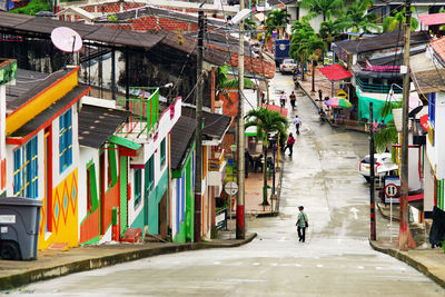 People walking on street amidst buildings in city