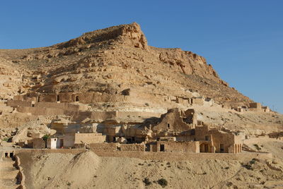 Low angle view of old ruins against clear blue sky