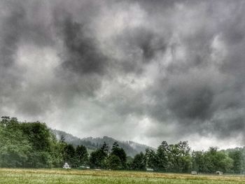Scenic view of field against cloudy sky