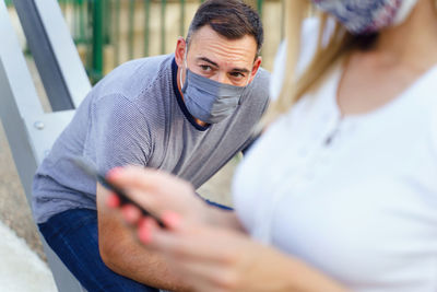 Midsection of man holding mobile phone outdoors