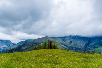Rear view of man standing on mountain against sky