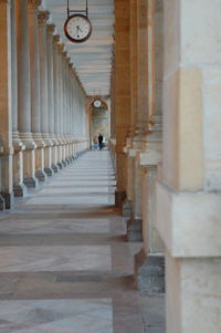 Rear view of people walking in corridor of building