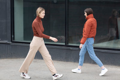 Side view of man and woman standing on footpath