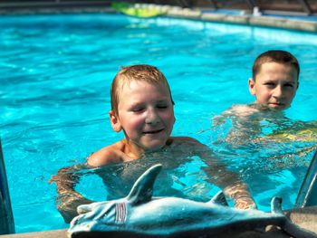 Brothers swimming in pool