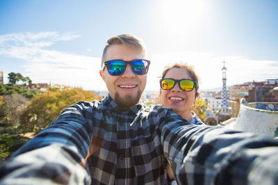 Portrait of smiling man wearing sunglasses against sky