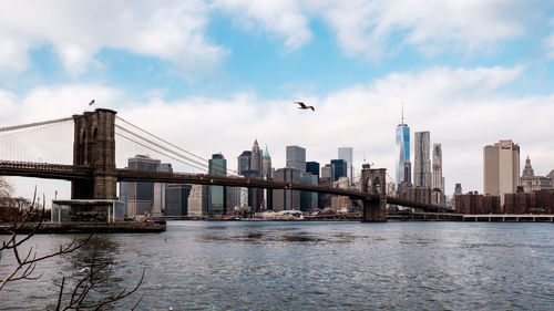 Brooklyn bridge over east river against one world trade center in city