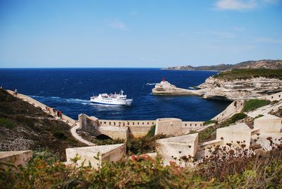 Ship sailing in sea against sky seen from hill