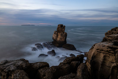 Rocks on sea shore against sky