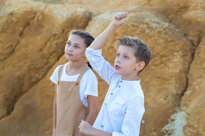 Surprised faces of children watching kite flying in the sky.