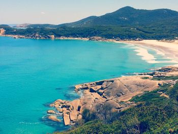 High angle view of sea and mountains against sky