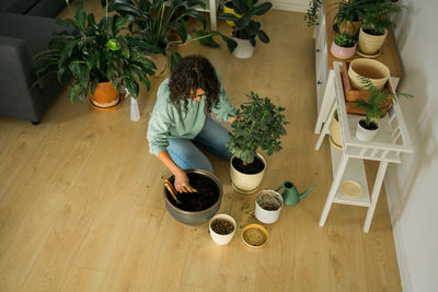 Low section of woman standing by potted plants