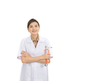 Smiling female doctor standing against white background