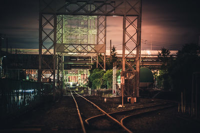 Train on railroad tracks against sky during sunset